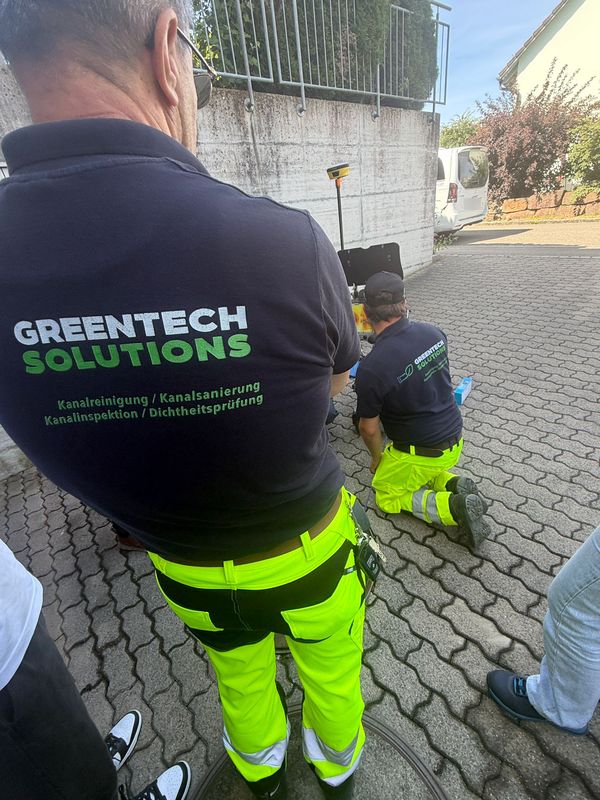 Zwei Greentech-Mitarbeiter bereiten die TV-Inspektion am offenen Schacht vor